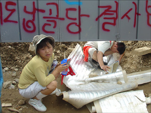 공사장 철문 바닥 땅을 파 출입하는 주민들 